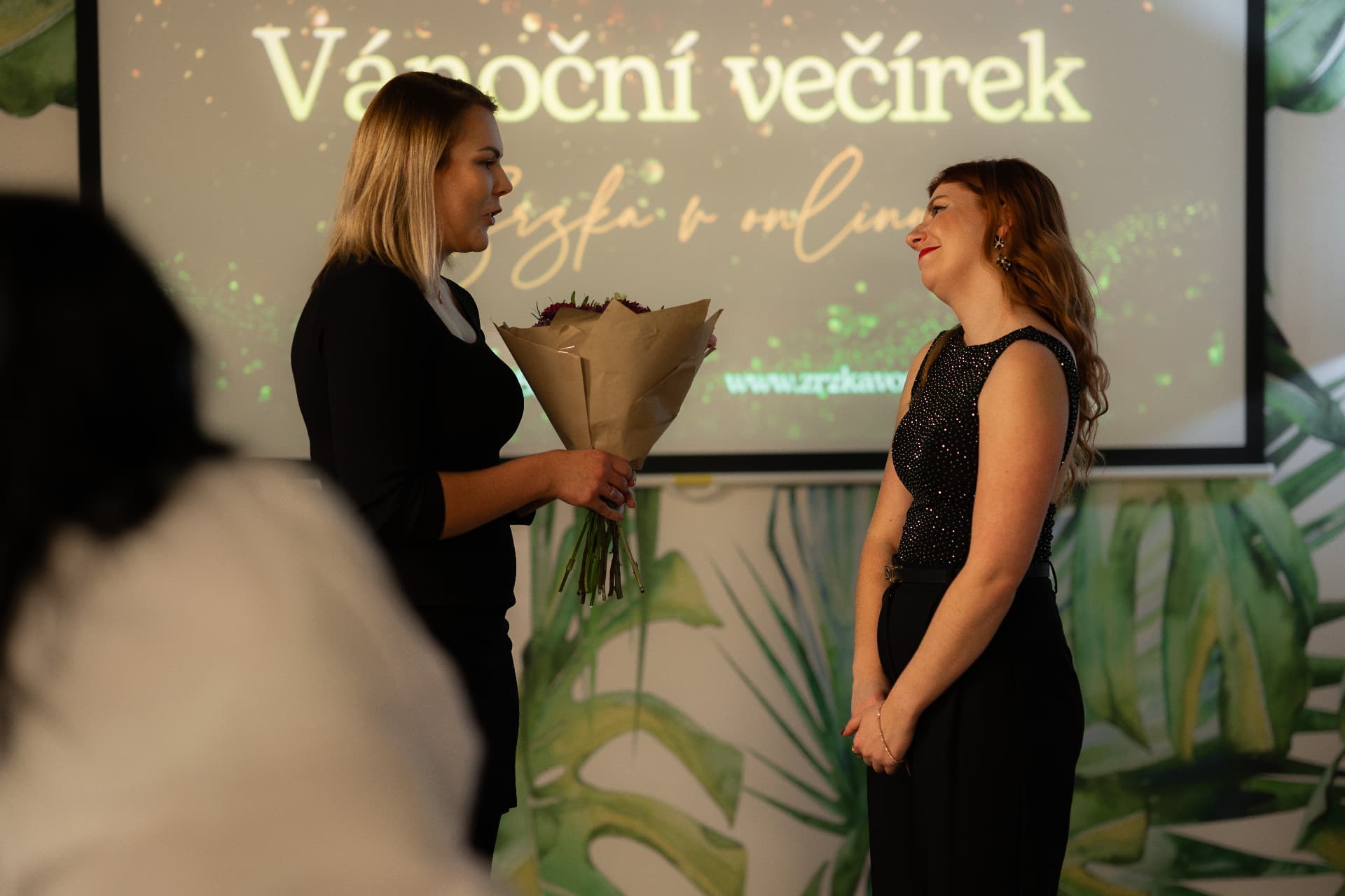 Předání kytice na vánočním večírku